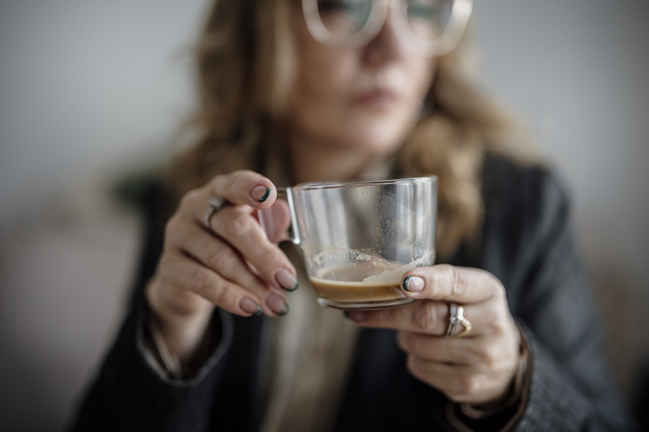 Woman holding a glass cup of coffee