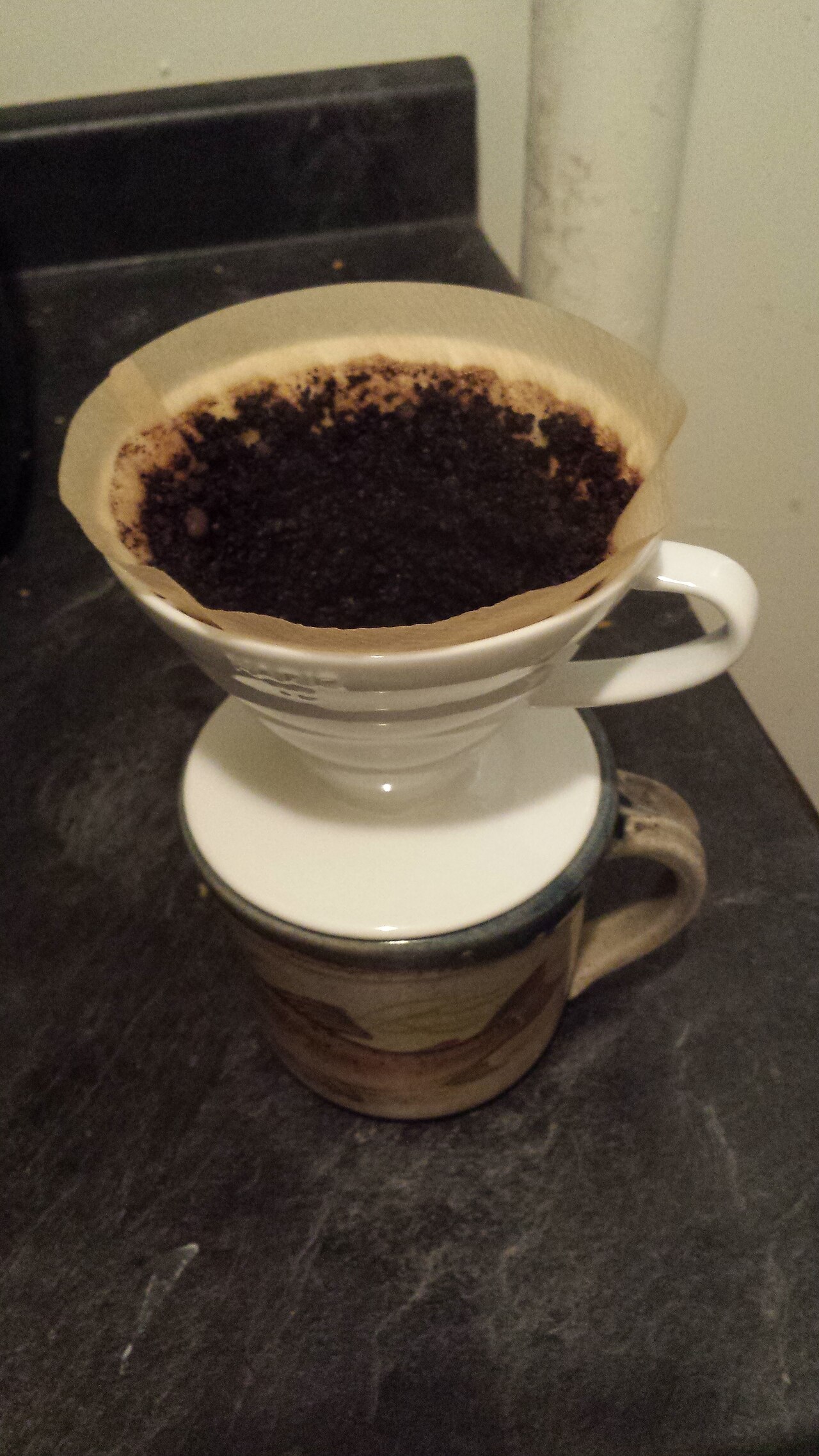 Pour-over dripper brewing coffee into a glass carafe